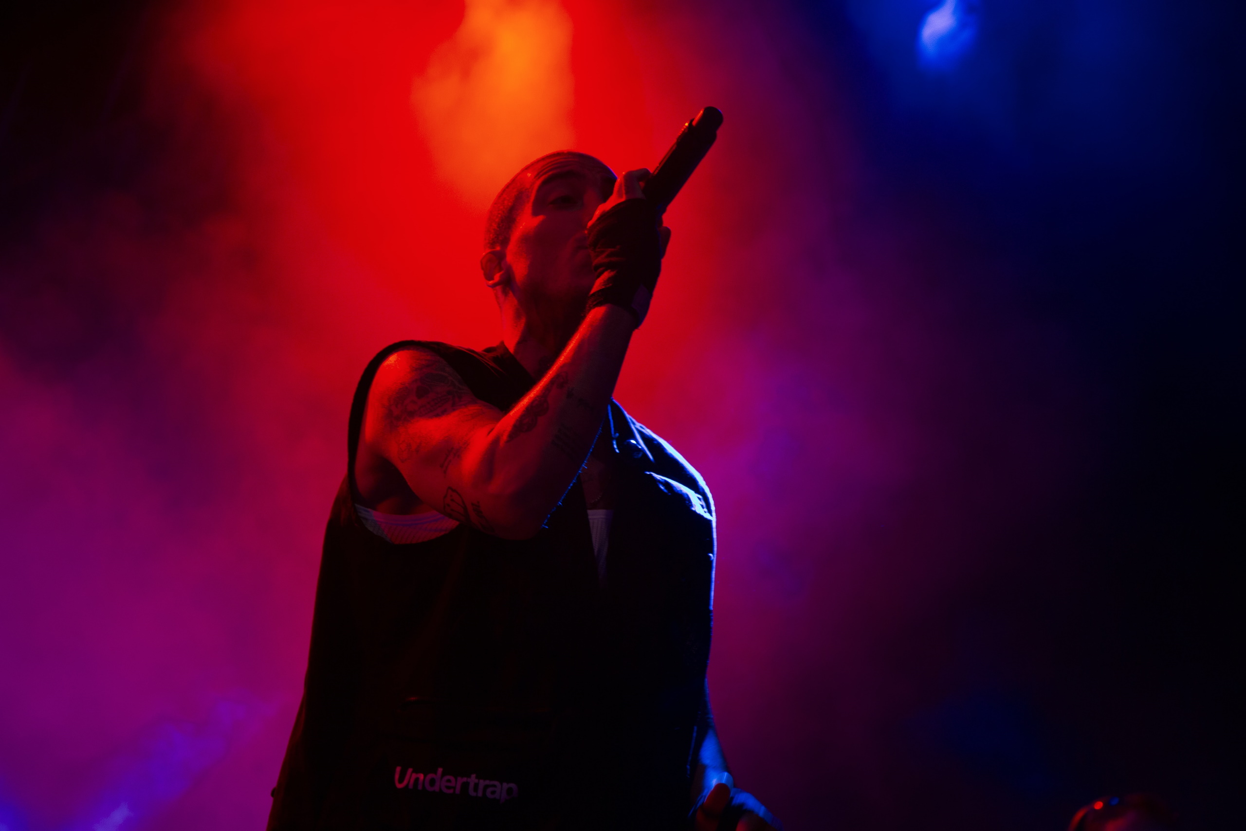 image of singer with wireless microphone under red spotlight