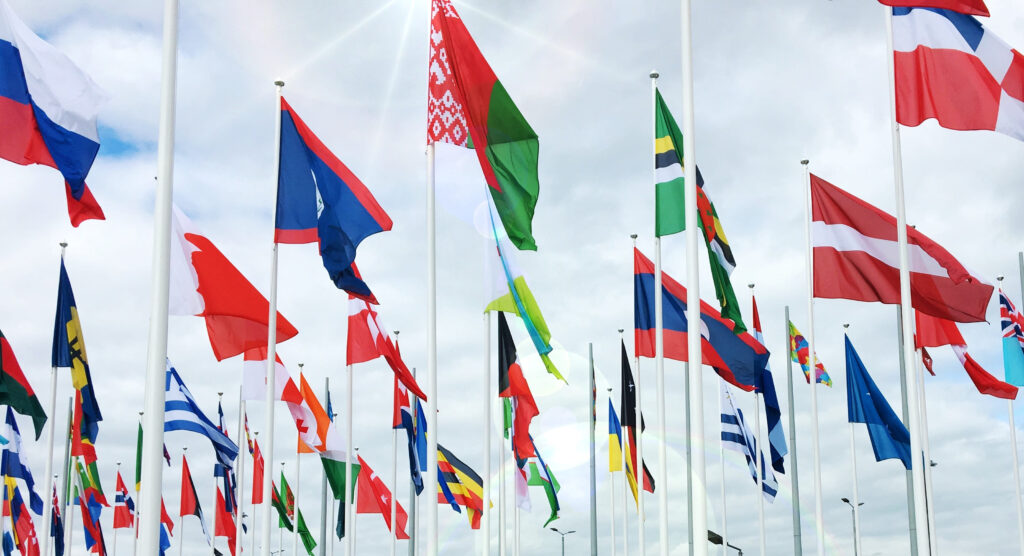 flags of many nations against a cloudy sky 